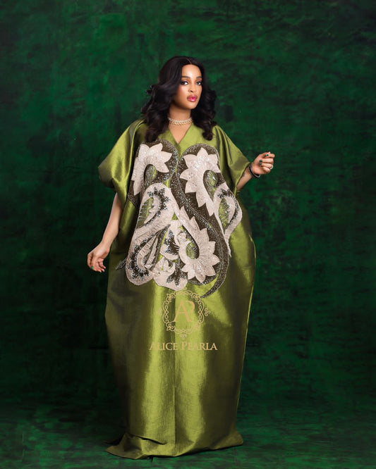 Woman wearing a green dress with floral embroidery on a dark green background