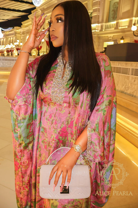 Woman in a colorful dress holding a handbag in an indoor setting